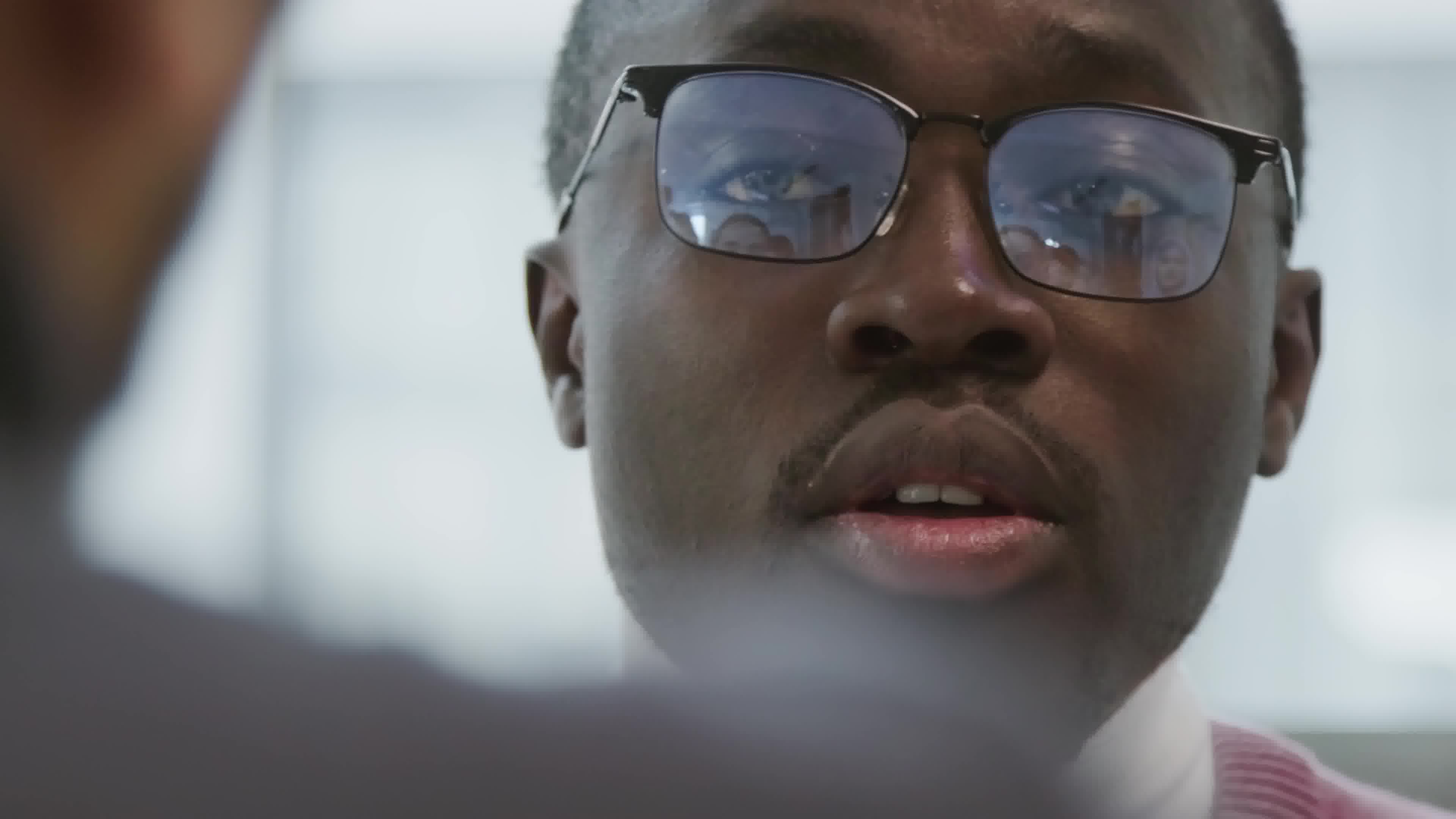 Professionnel en visioconférence, reflet d'une réunion dans ses lunettes